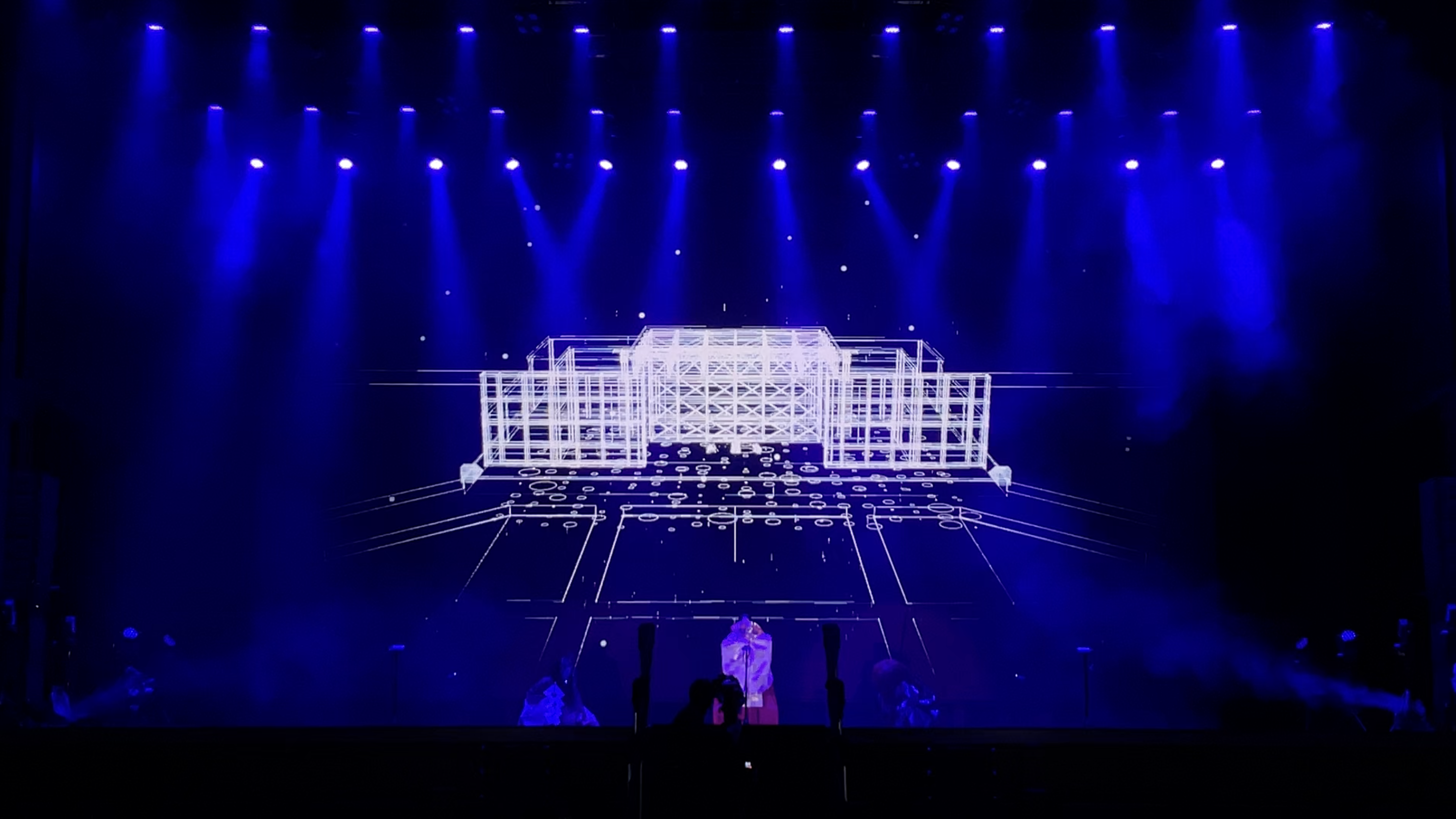 Blue-lit stage with architectural line projections at FUTURE 能–NOH STAGE at Expo 2025 — Keigo Yoshida (吉田慧悟)